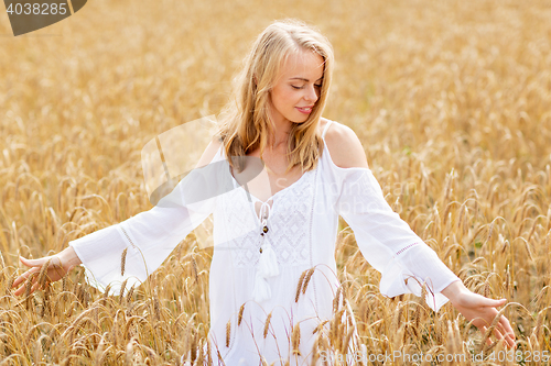 Image of smiling young woman in white dress on cereal field