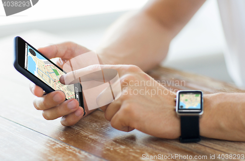 Image of close up of hands with smart phone and watch