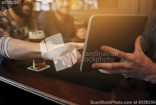 Image of close up of men with tablet pc and beer at bar