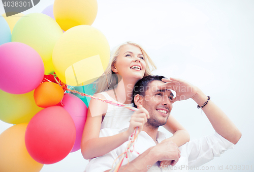 Image of couple with colorful balloons at seaside