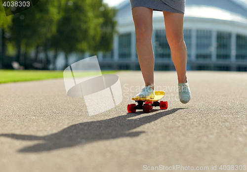 Image of close up of female feet riding short skateboard