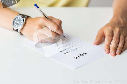 Image of close up of hands with vote or ballot on election