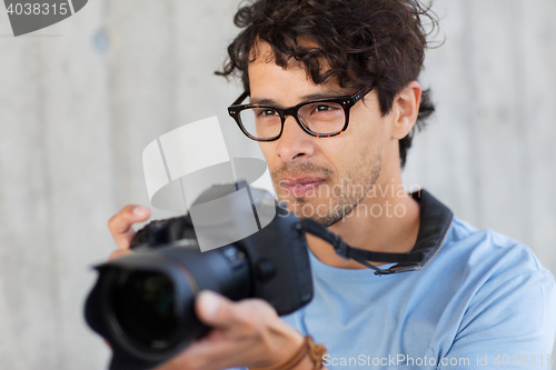 Image of photographer with digital camera shooting in city