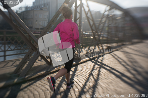 Image of sporty woman jogging on morning