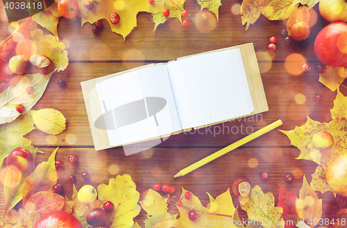 Image of empty note book with pencil and autumn leaves