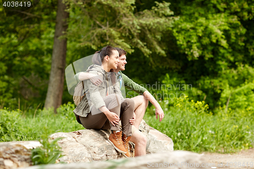 Image of smiling couple with backpacks in nature