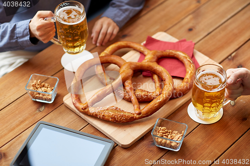 Image of close up of man drinking beer with pretzels at pub