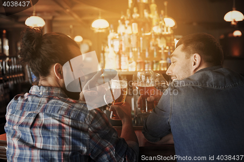 Image of happy male friends drinking beer at bar or pub