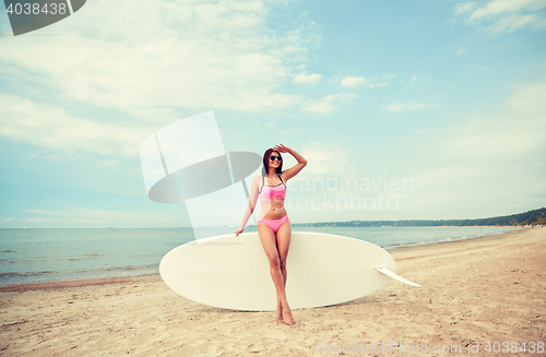 Image of smiling young woman with surfboard on beach