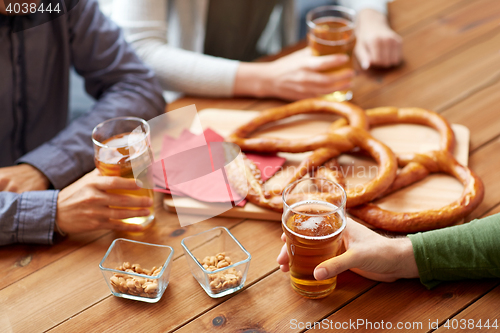 Image of close up of men drinking beer with pretzels at pub