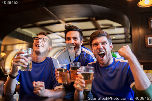 Image of football fans or friends with beer at sport bar