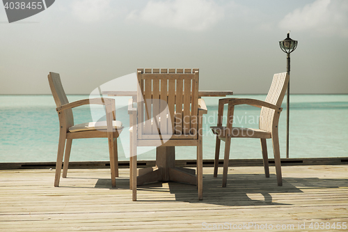 Image of outdoor restaurant terrace with furniture over sea