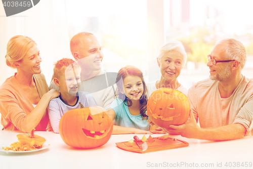 Image of happy family sitting with pumpkins at home