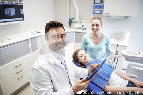 Image of dentist with tablet pc, patient girl and mother