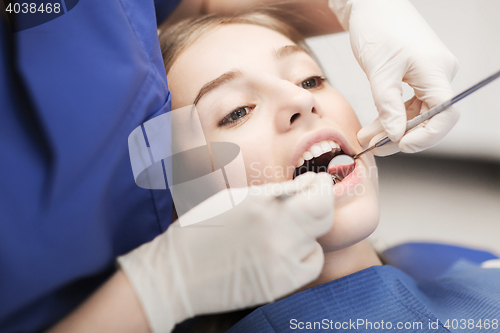Image of female dentist checking patient girl teeth