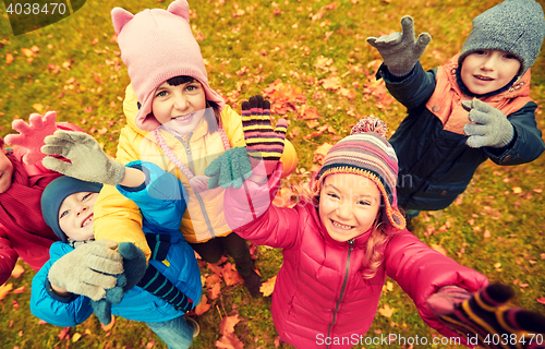 Image of happy children waving hands in autumn park