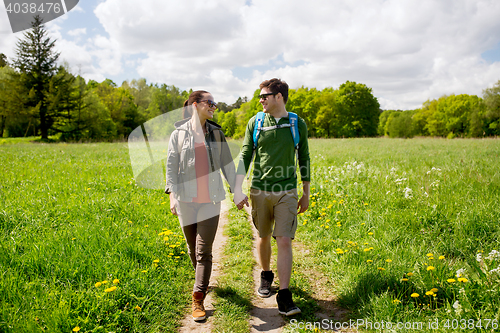 Image of happy couple with backpacks hiking outdoors