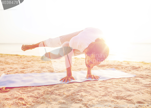 Image of man doing yoga exercises outdoors