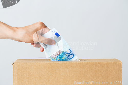 Image of man putting euro money into donation box