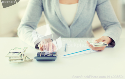 Image of close up of hands counting money with calculator