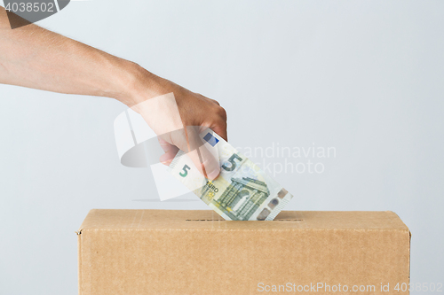 Image of man putting euro money into donation box