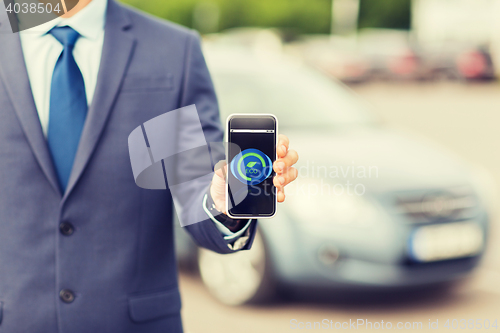 Image of close up of business man with smartphone and car