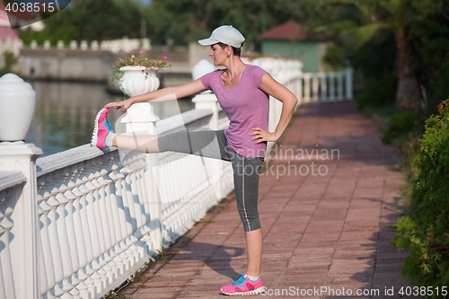 Image of woman  stretching before morning jogging