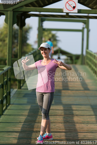 Image of woman  stretching before morning jogging