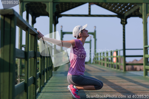 Image of woman  stretching before morning jogging