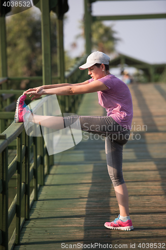 Image of woman  stretching before morning jogging