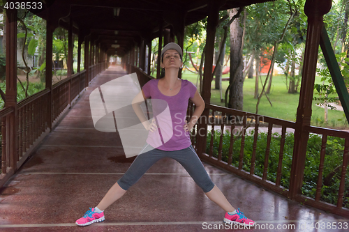 Image of woman  stretching before morning jogging