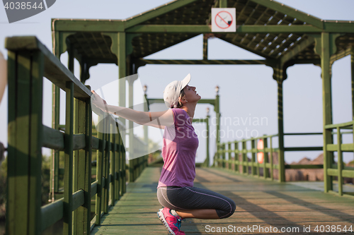 Image of woman  stretching before morning jogging