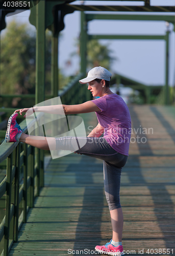 Image of woman  stretching before morning jogging