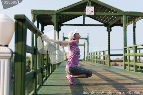 Image of woman  stretching before morning jogging