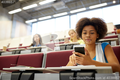 Image of african student girl with smartphone at lecture