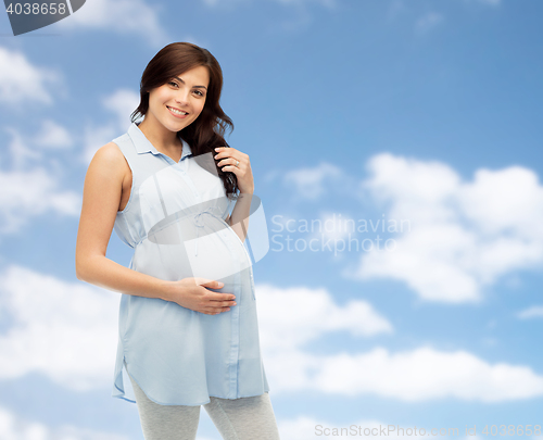 Image of happy pregnant woman touching her big belly