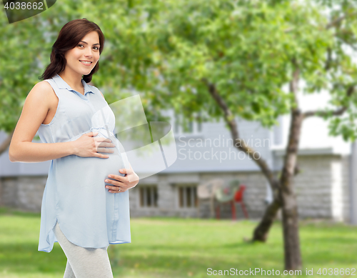 Image of happy pregnant woman touching her big belly