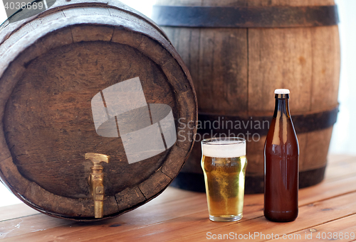 Image of close up of old beer barrel, glass and bottle