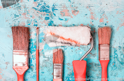 Image of Set Of Paint Brushes On A Blue Wooden Background