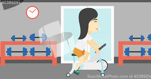 Image of Woman riding stationary bicycle.