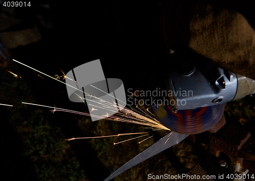 Image of Worker cutting metal with grinder. Sparks while grinding iron