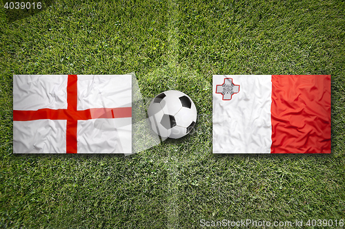 Image of England and Malta flags on soccer field