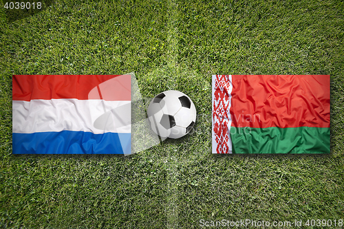 Image of Netherlands and Belarus flags on soccer field