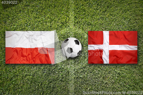 Image of Poland and Denmark flags on soccer field