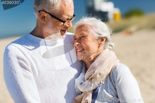 Image of happy senior couple hugging on summer beach