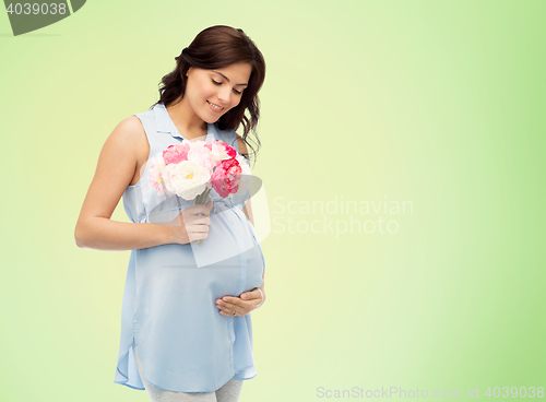 Image of happy pregnant woman with flowers touching belly