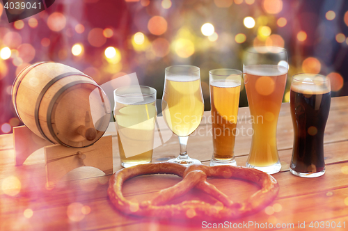 Image of close up of beer glasses, barrel and pretzel