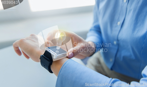 Image of close up of hands with smart watch and light bulb