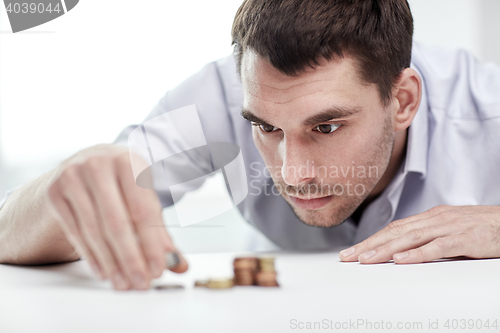 Image of businessman with coins at office