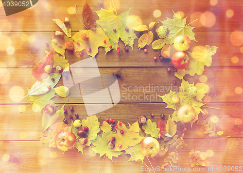 Image of set of autumn leaves, fruits and berries on wood